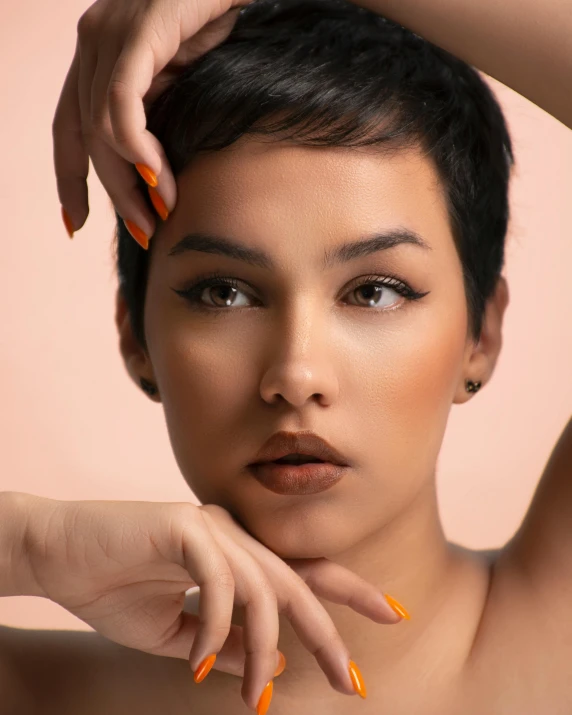 a woman with orange nails holding her head