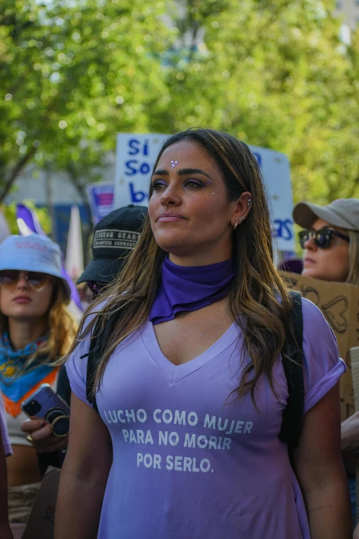 a woman in purple shirt with protest slogan on it