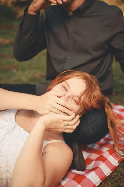 a woman laying on top of a checkered blanket