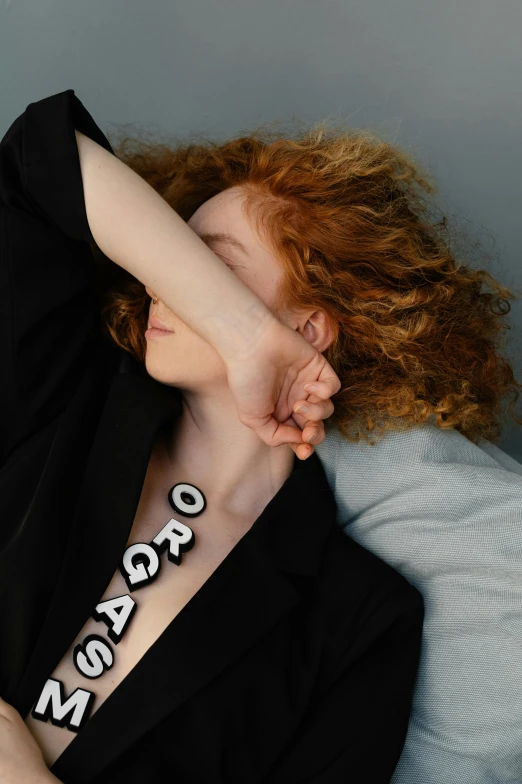 a woman with red hair covers her face with her hand