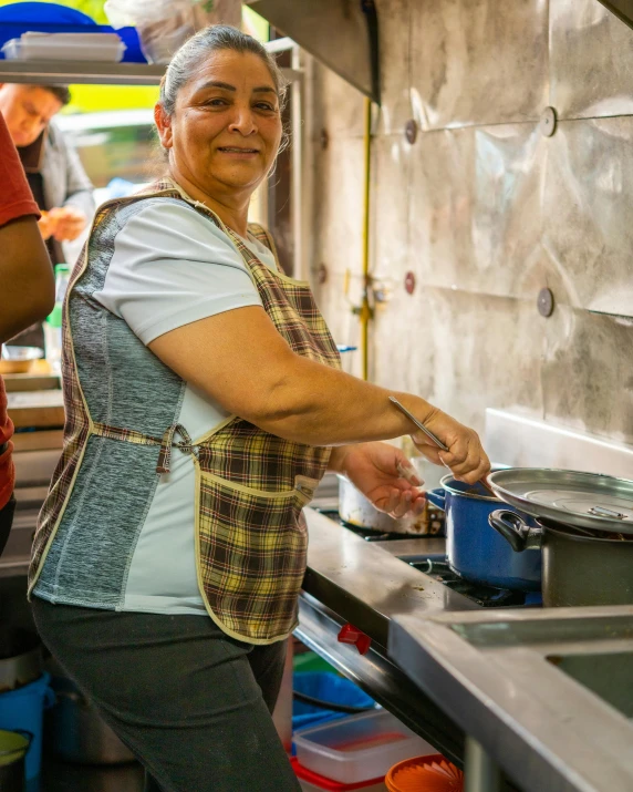 a person holding a pot in an oven with an lid