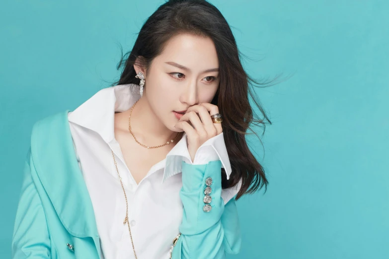 a young woman posing in a white shirt and turquoise jacket