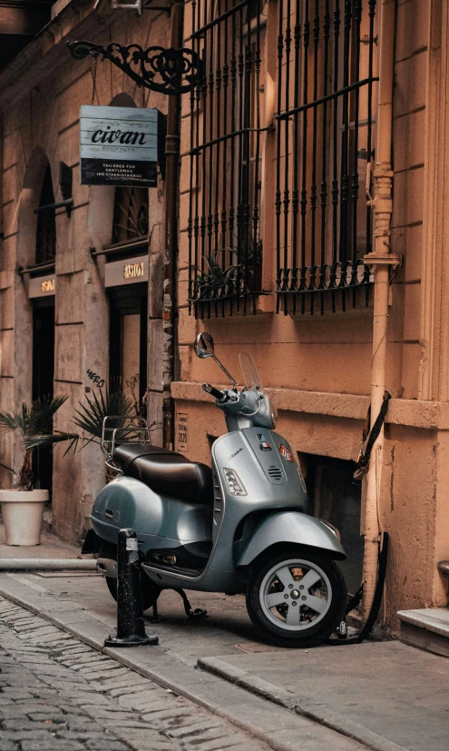 a silver scooter sitting on a street next to a building