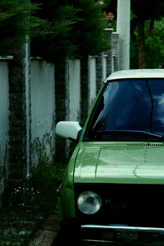 a green truck parked next to a wall