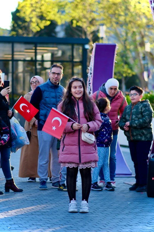 a person in pink and white holding two turkish flags