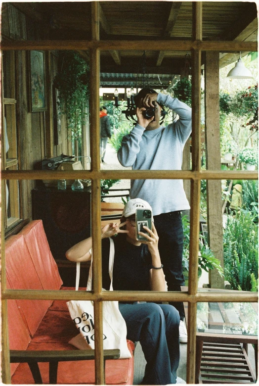 two people taking pictures through a mirror