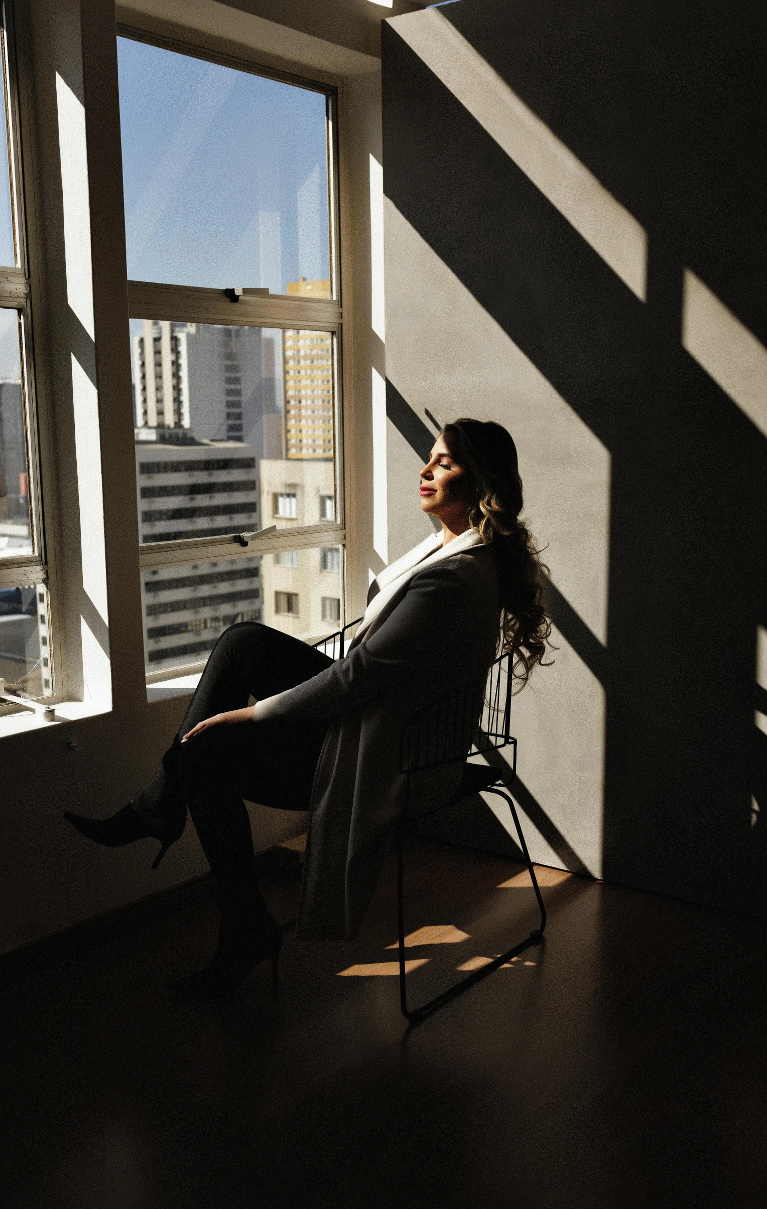 a woman sitting in a chair in front of a window