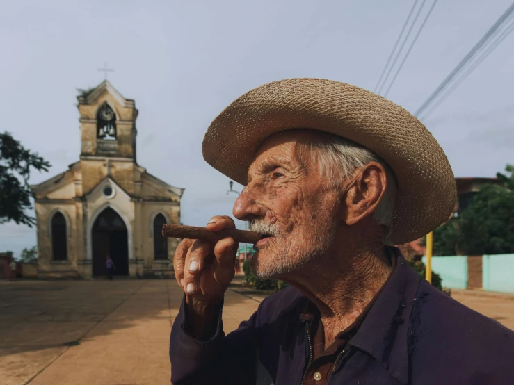 an old man in a straw hat smoking a cigar