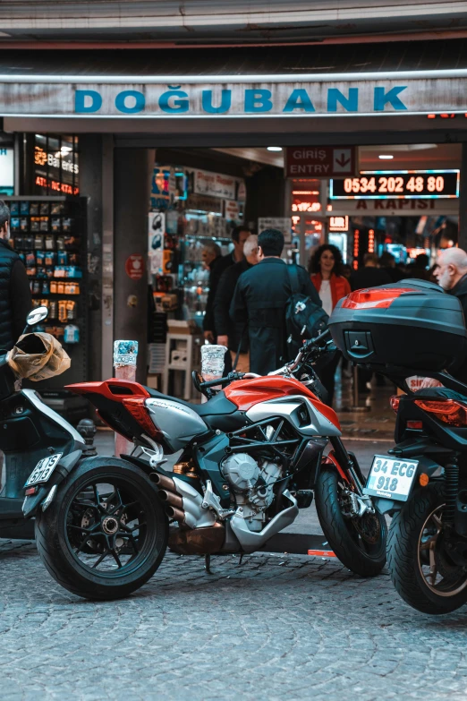 two motorcycles are parked in front of a bank