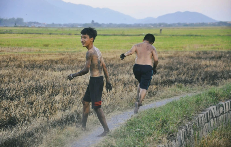 two men running on a trail in the grass