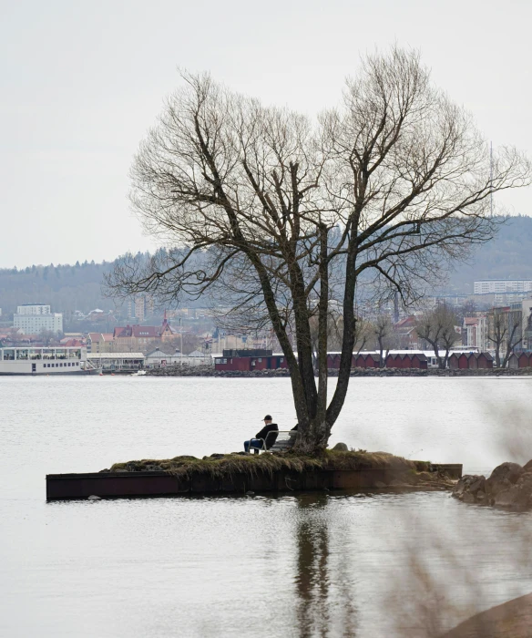 two people sit on an island in a large lake