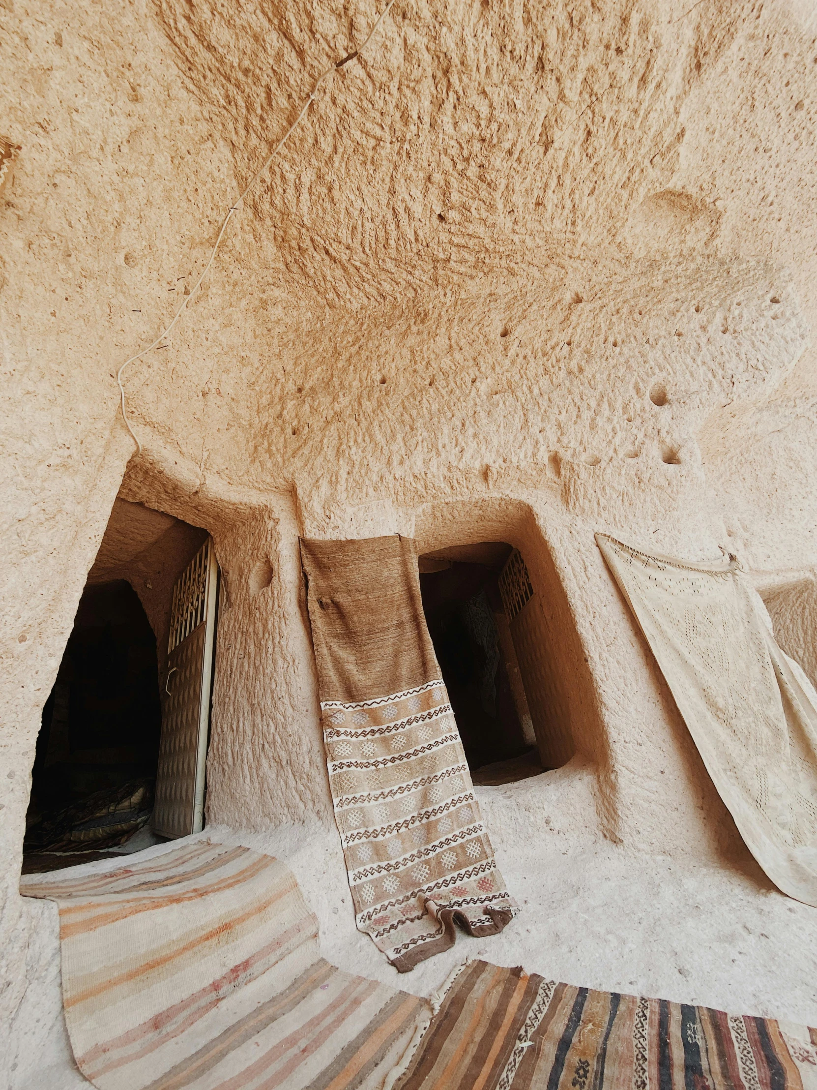 several pieces of wool are scattered on the floor inside an adobe home