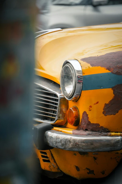 an old yellow taxi cab is shown with rust on it