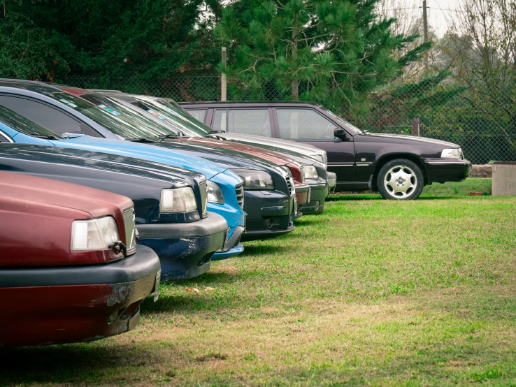 many vehicles lined up in a line on the grass