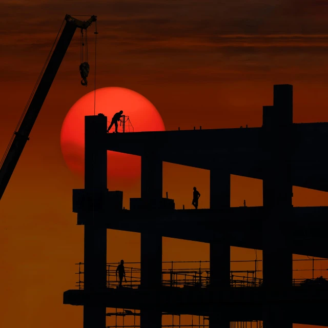 the sun is setting on a building construction site