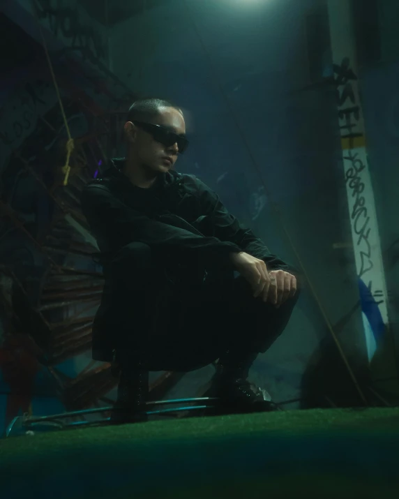 a man wearing sunglasses sitting in the dark