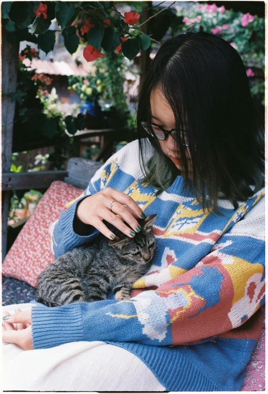 the girl is cuddling her cat outside on the couch