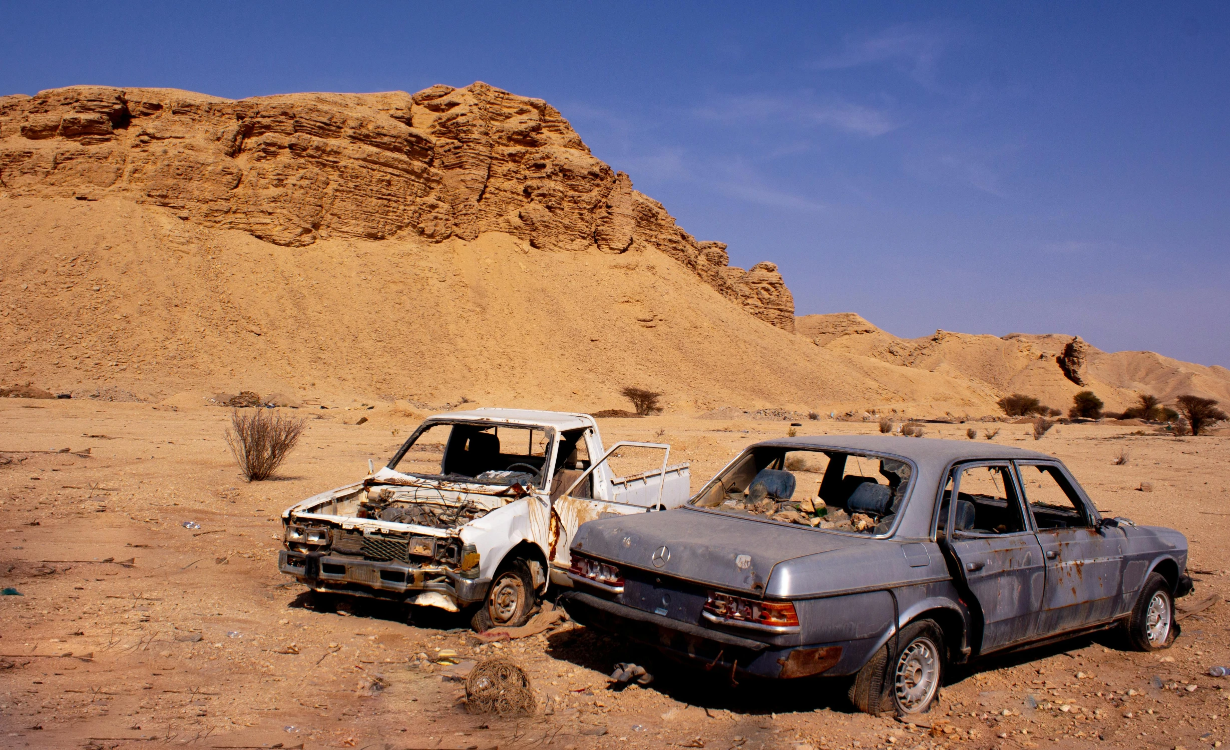 two old cars in the desert on a sunny day