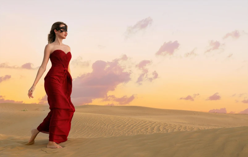 a beautiful woman walking across a desert during the day