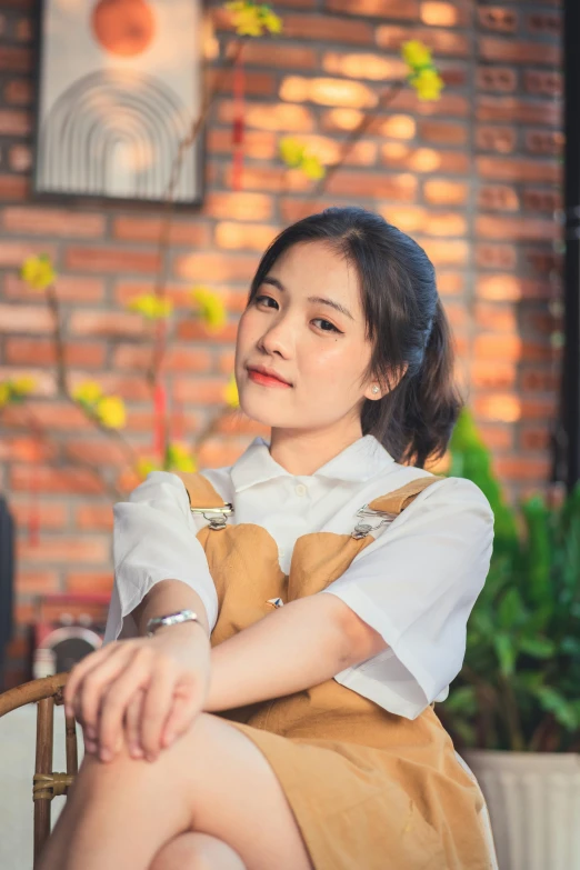 an asian woman sitting in front of a wall