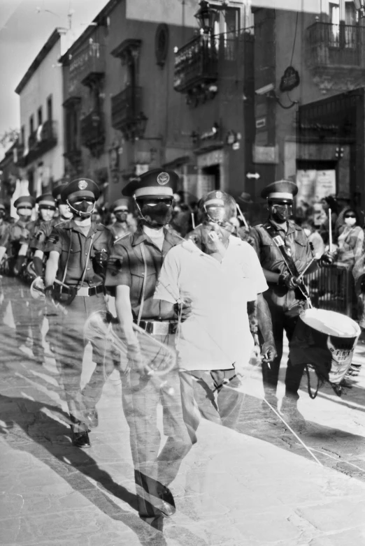 many men in hats and uniforms are walking down a street