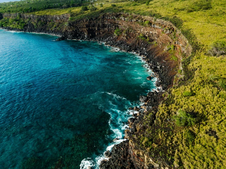 a scenic cliff with some green grass on the sides