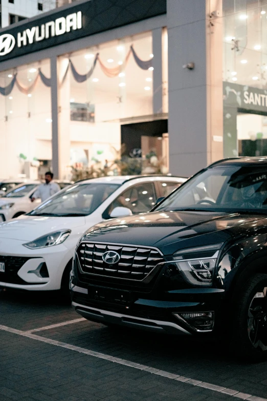 a group of parked cars on a road in front of a store