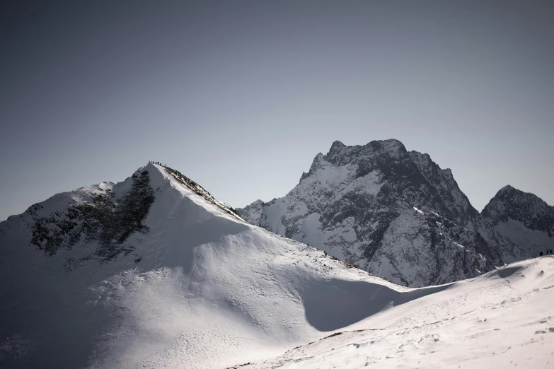 a snowboarder jumping off a steep snowy mountain side