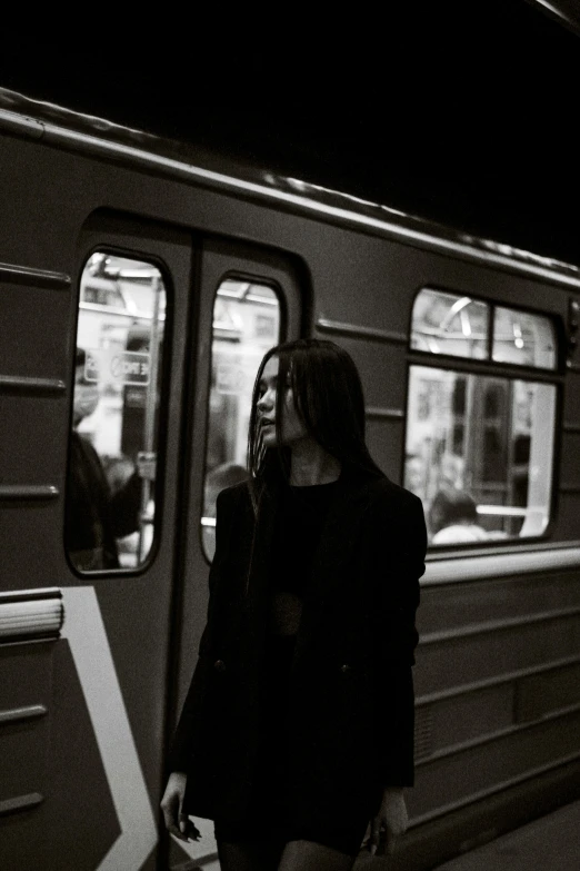 a black and white po of people walking by a train