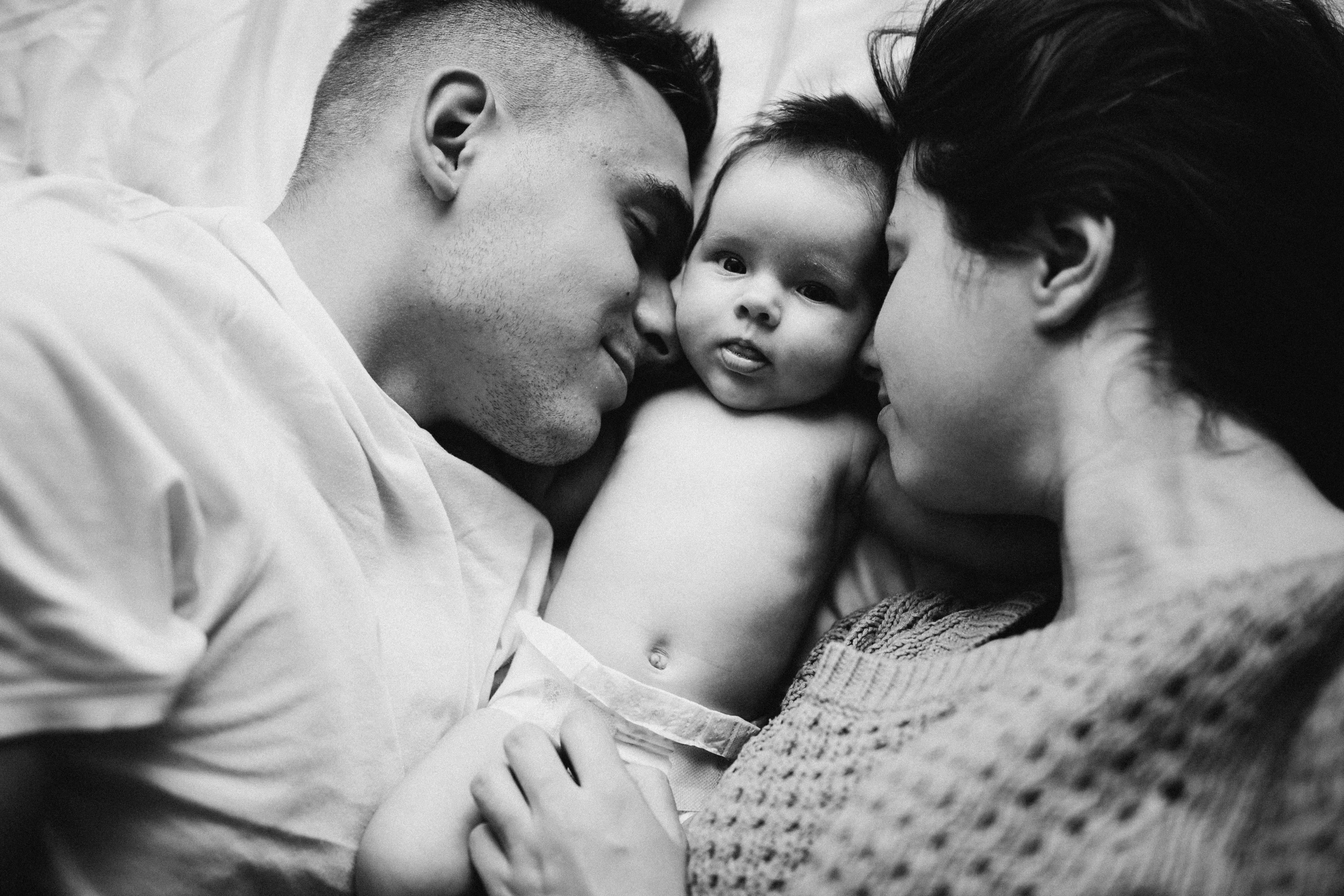 a black and white po of three people with a baby