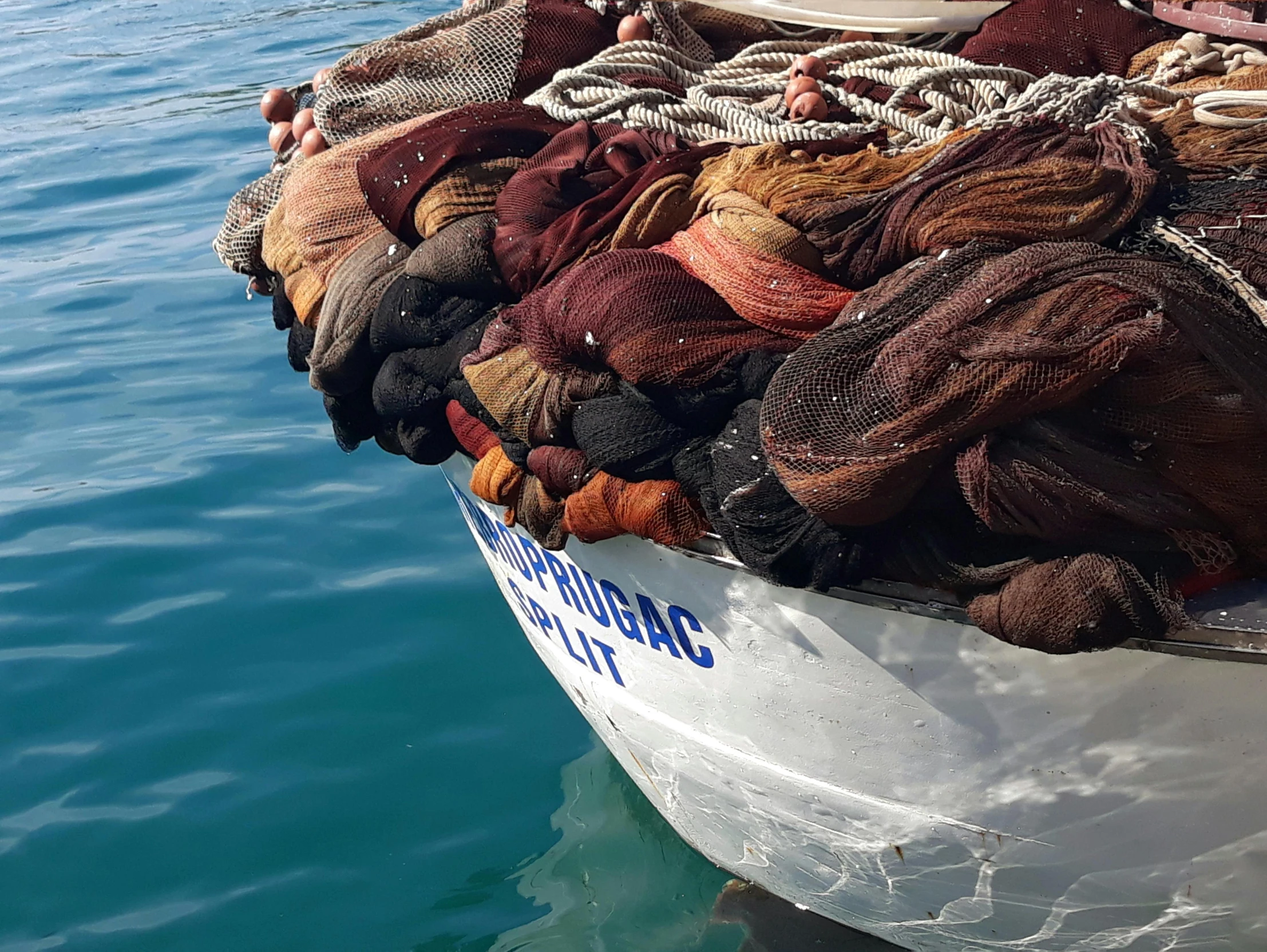 fishing nets are piled high on a boat