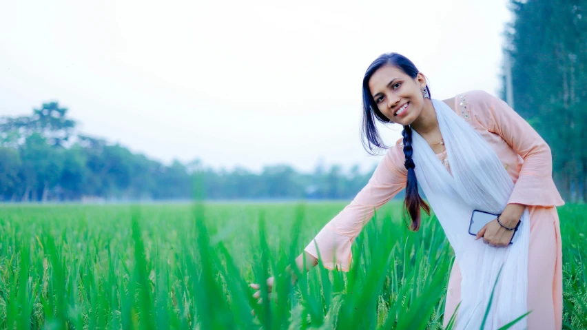 a girl is posing for the camera in the green grass