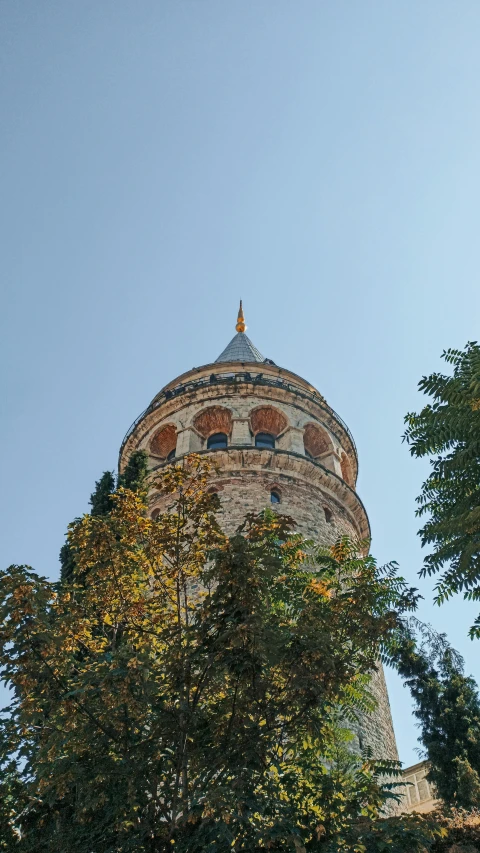 a tall white and tan building surrounded by trees