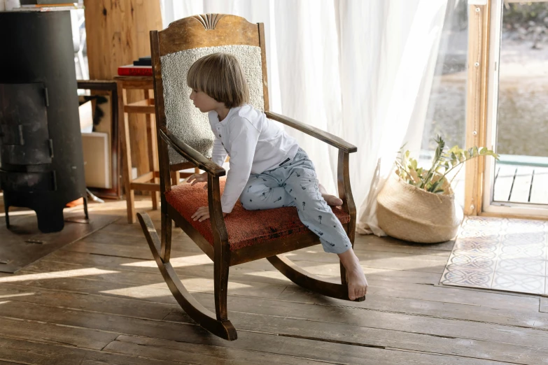 a young child is sitting on a rocking chair