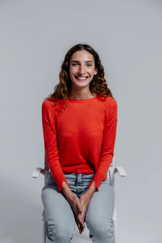 a woman in a red sweater poses for a picture