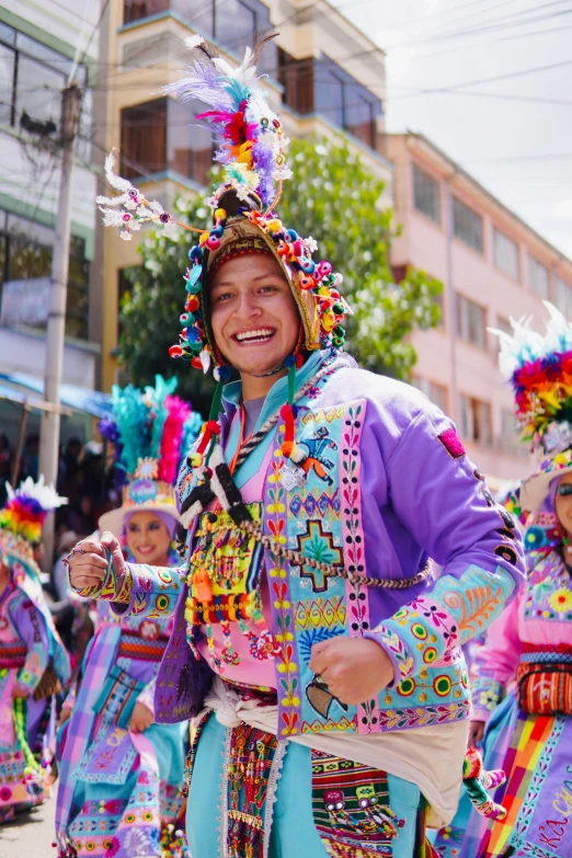 a group of colorfully dressed men dance in a parade