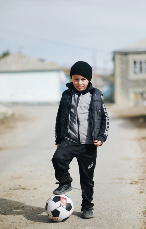 a  standing in the dirt near a soccer ball