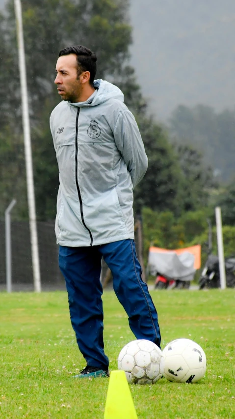 a man standing by a soccer ball on a field