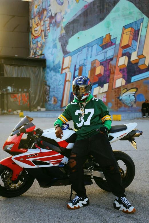 a person with a helmet on standing next to a red motorcycle