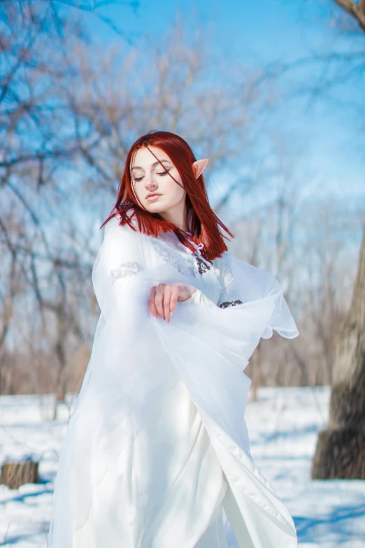 the bride in white, her hair in red is falling from a large shawl