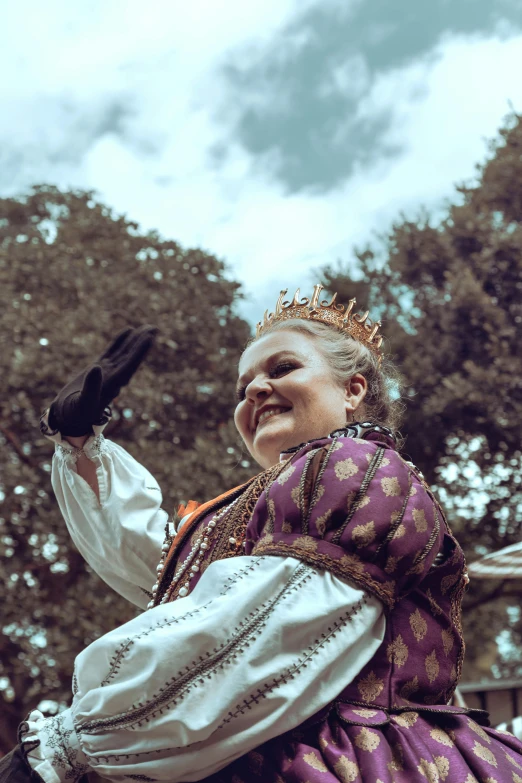 a  in a medieval dress with trees in the background