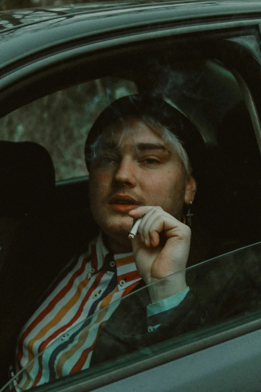 a man smoking a cigarette in a car