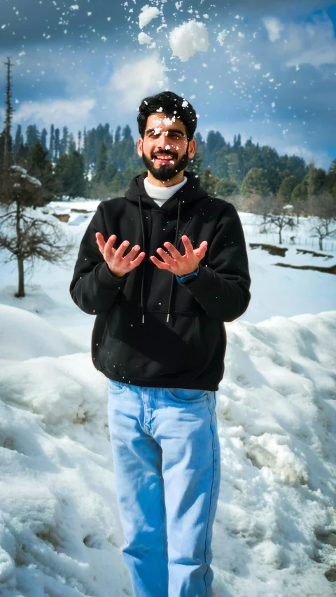 a man standing in snow with his hands up