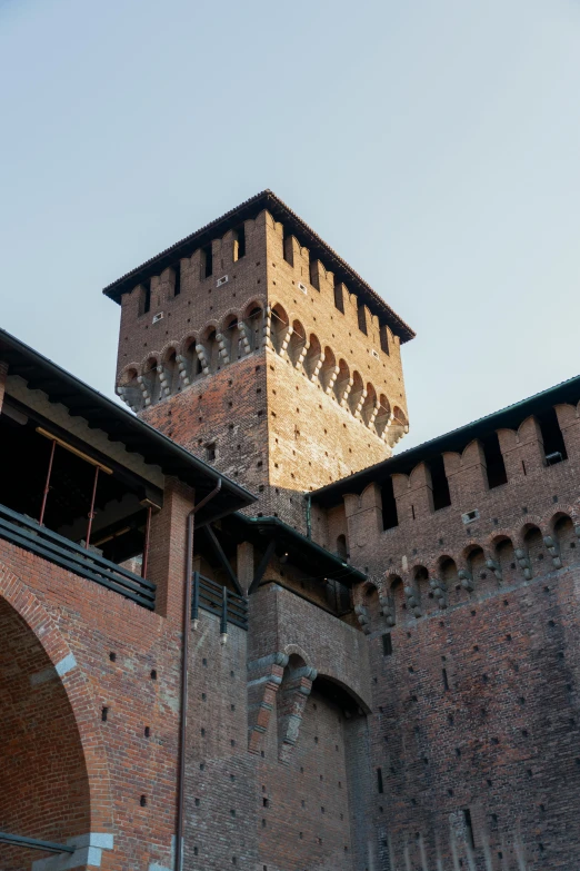 an outdoor brick area where you can see the top of a tall building