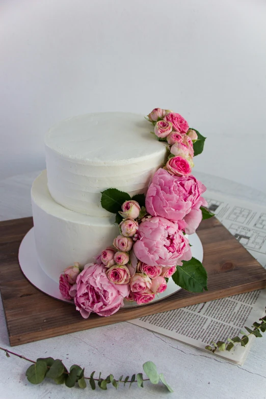 three tier white cake with pink flowers on top