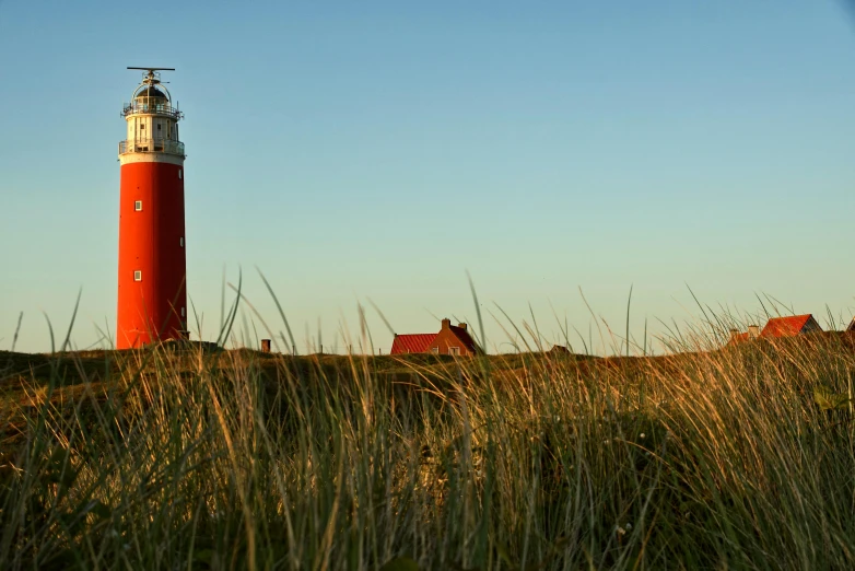 a lighthouse sitting on top of a grassy hill