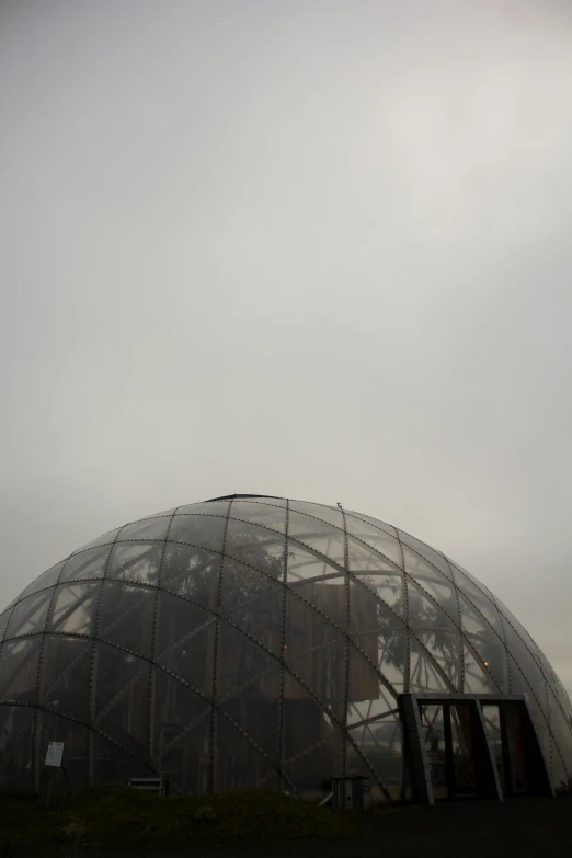 an unusual structure with glass walls and a circular roof