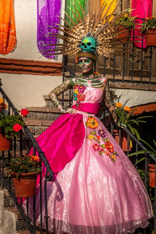 a woman in pink dress standing next to pots of plants