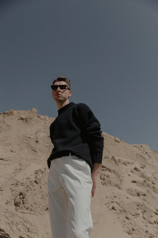 a man standing in the sand near his feet