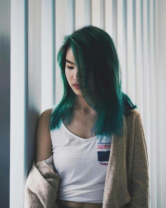 an asian woman with blue hair wearing a tan sweater